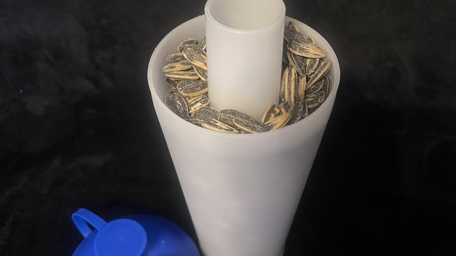 The ProSeed cup with sunflower seeds inside.