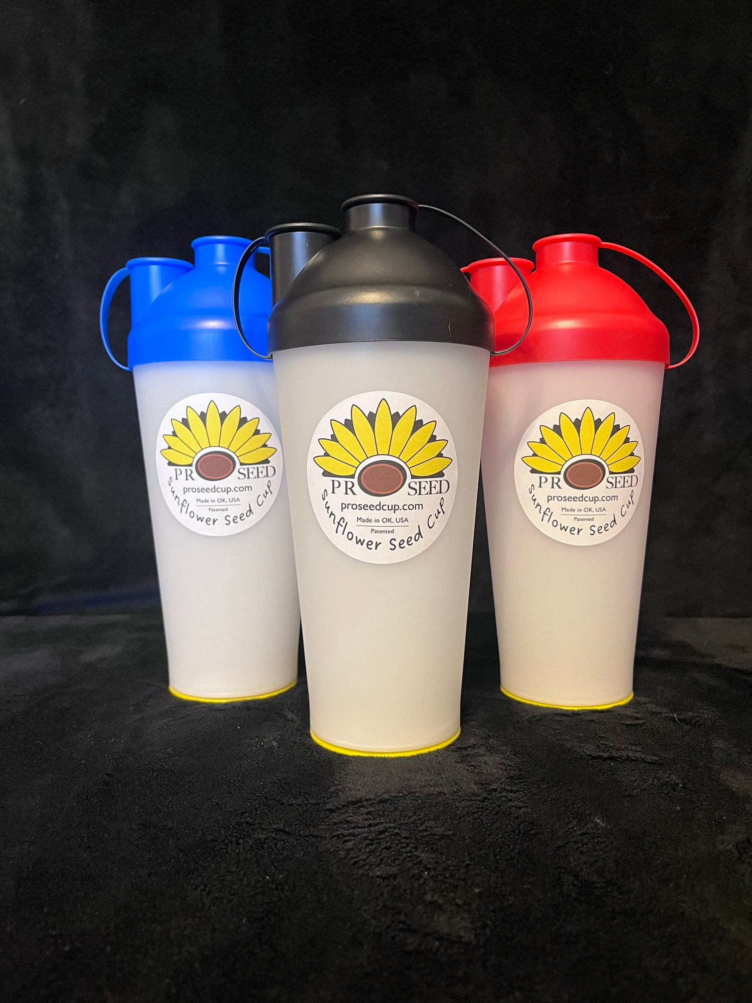 The ProSeed sunflower seed snack cup  with blue, black, and red lids.