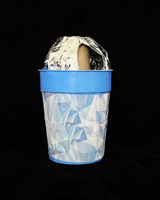 An old cup with aluminum foil on the top